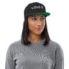 Person wearing a black cap with text.