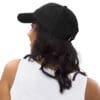 Person wearing a black cap, back view.