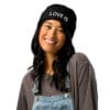 Smiling woman in black beanie and overalls.