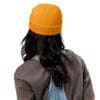Person wearing an orange beanie and overalls.