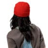 Person wearing a red beanie and denim overalls.