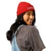 Smiling person wearing a red beanie hat.