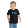 Child wearing black t-shirt with "I AM" design.