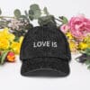 Black cap with "LOVE IS" text design.