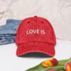 Red cap with "LOVE IS" embroidered.