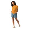 Smiling woman wearing orange t-shirt and shorts.