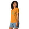 Smiling woman wearing orange shirt with text.