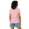 Woman wearing pink shirt and denim shorts.