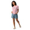 Woman wearing pink shirt and denim shorts.